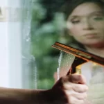 Portrait of woman cleaning glass window
