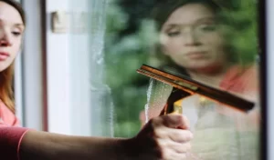 Portrait of woman cleaning glass window