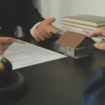 Justice and law concept legal counsel presents to the client a signed contract with gavel and legal law or legal having team meeting at law firm in background