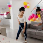 Cleaning living room after party african american women surrounded by colorful balloons