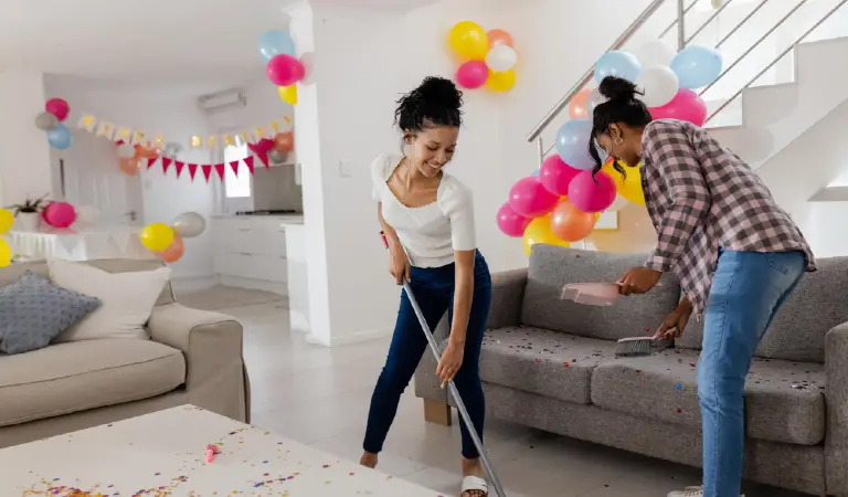 Cleaning living room after party african american women surrounded by colorful balloons