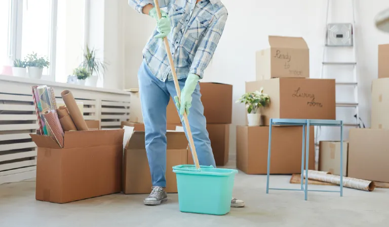 Low section portrait of happy young woman cleaning new house or apartment while moving in