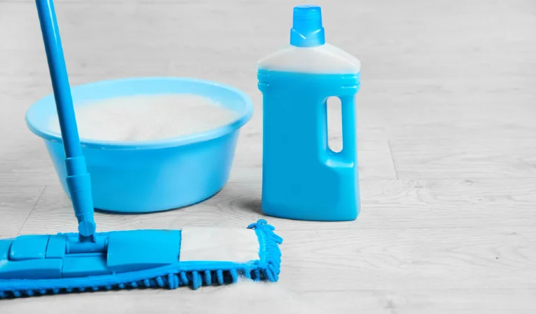Mopping blue wet microfiber mop with detergent cleaning disinfection kit on a white floor isolated housekeeping concept