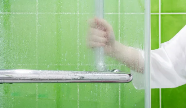 Young woman open glass partition in the bathroom